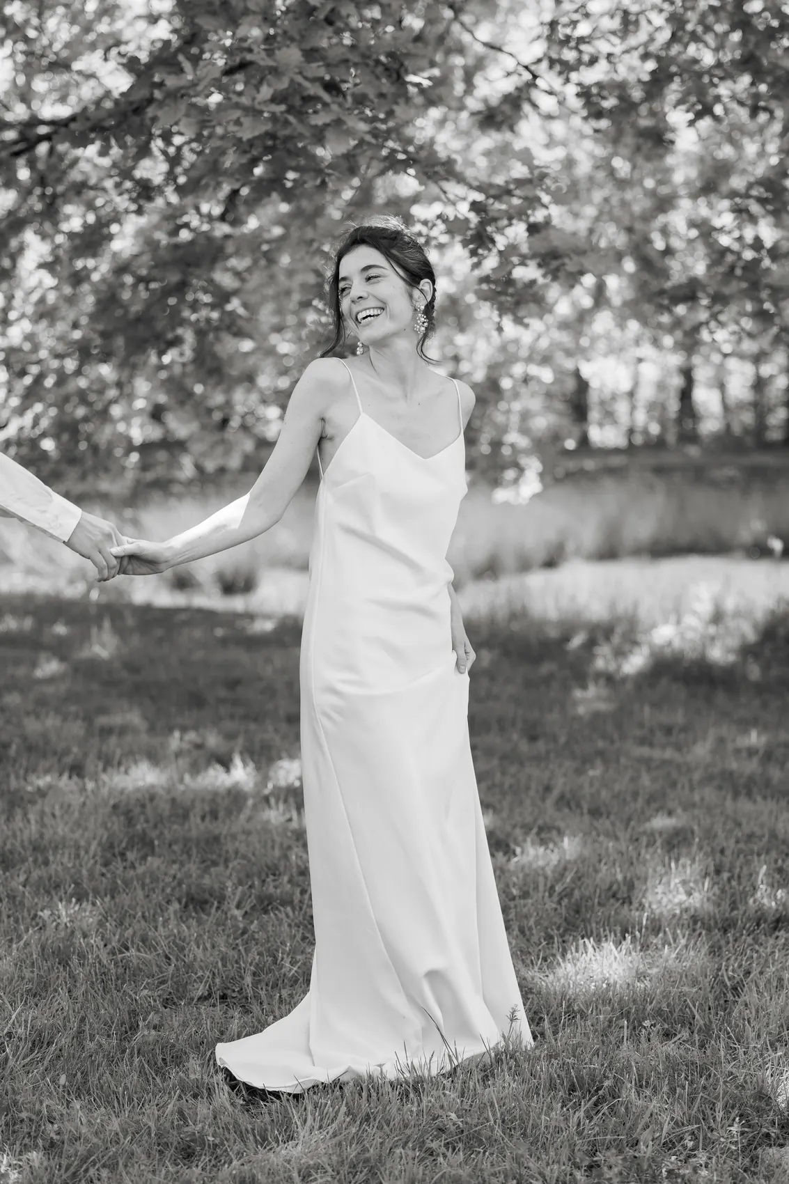 La mariée seule sous un arbre, robe fluide, en noir et blanc