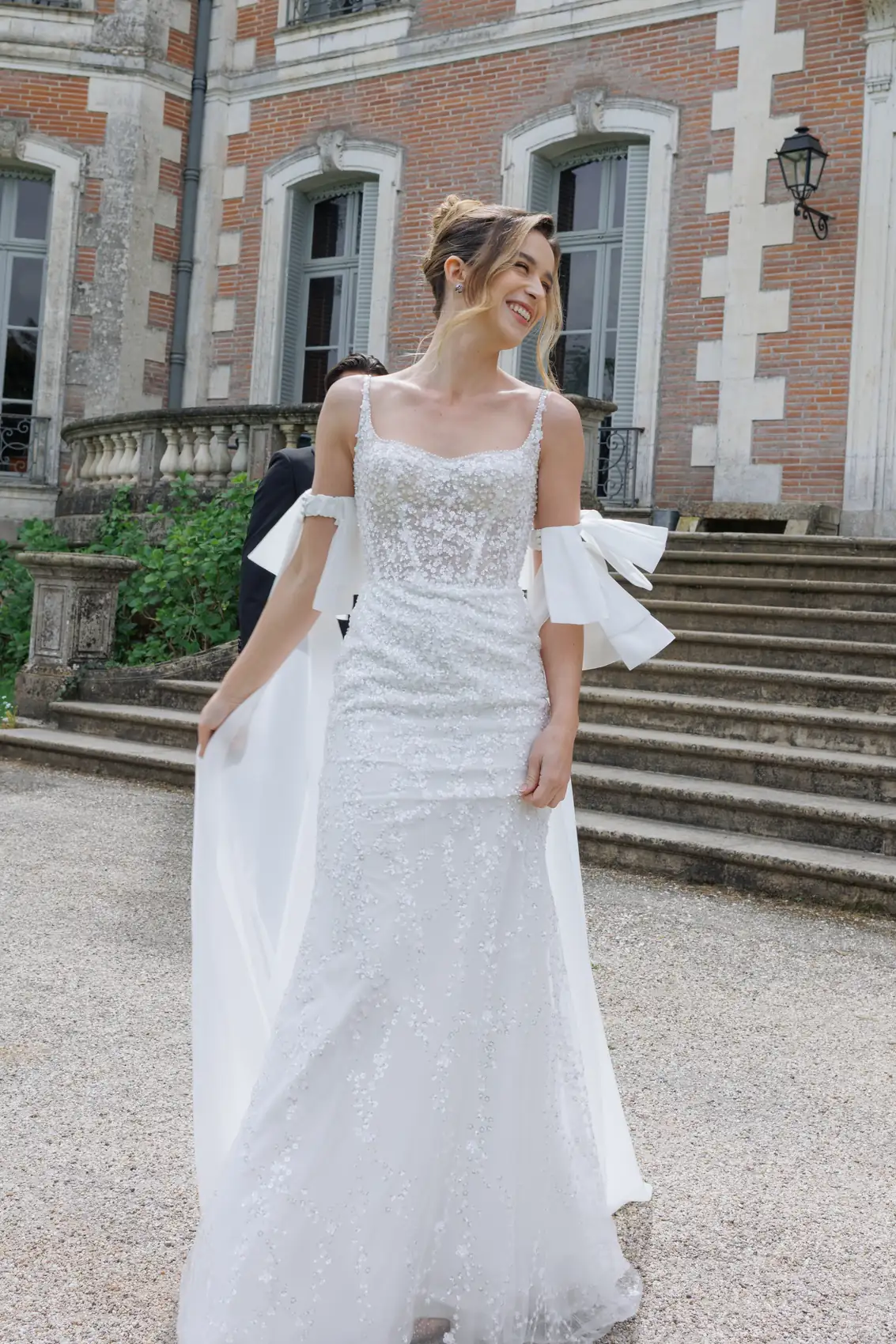 La mariée descend les marches devant la façade du château
