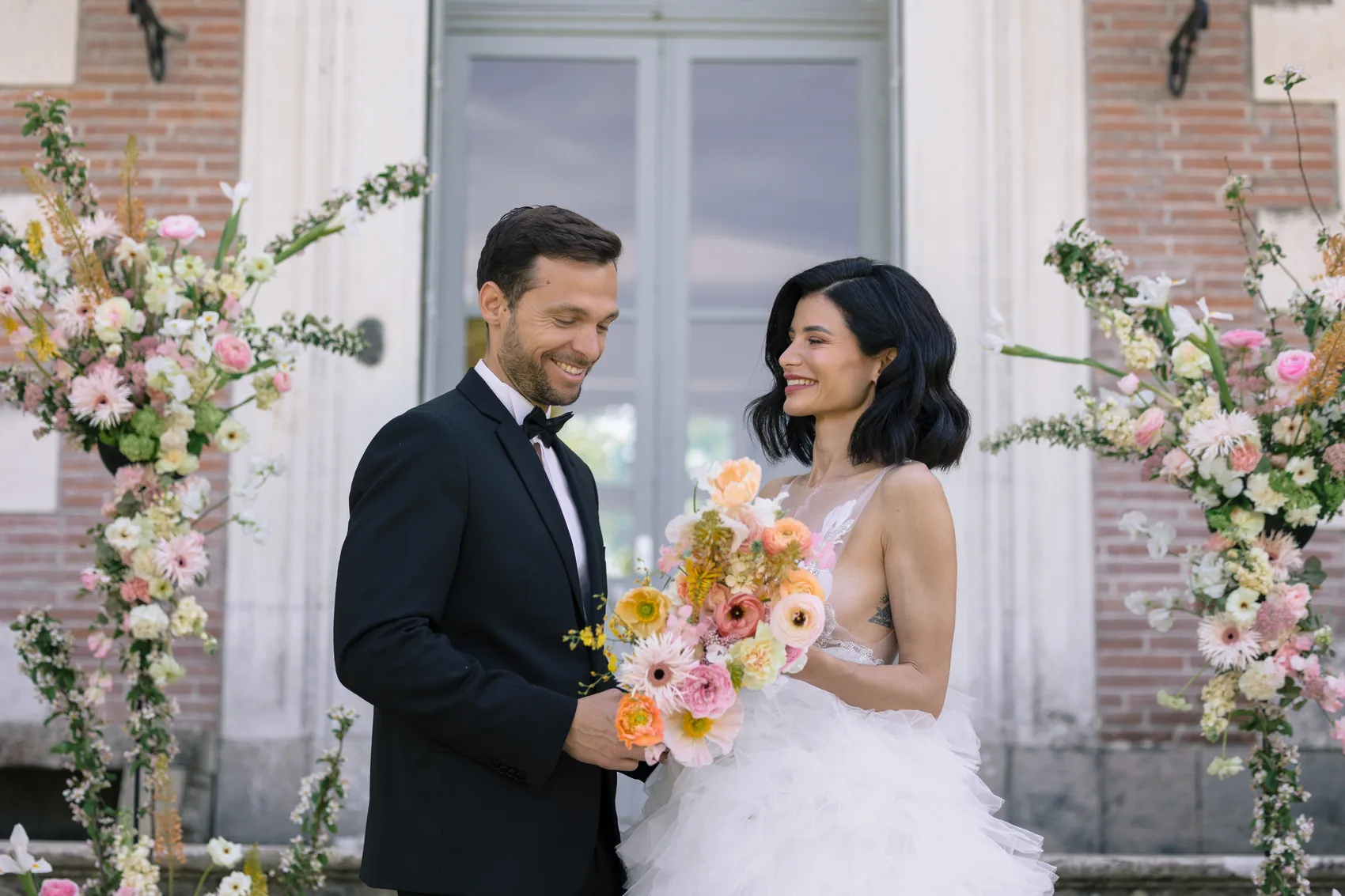 Les mariés face à face entre deux arches florales