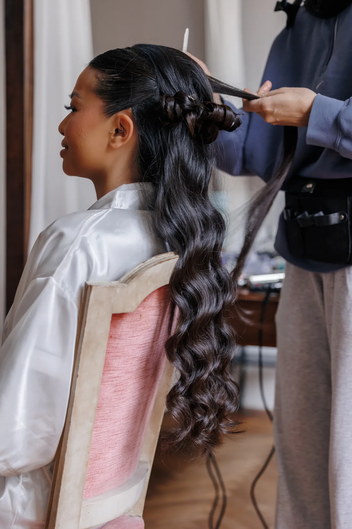 Coiffure de la mariée, mains du coiffeur dans ses cheveux