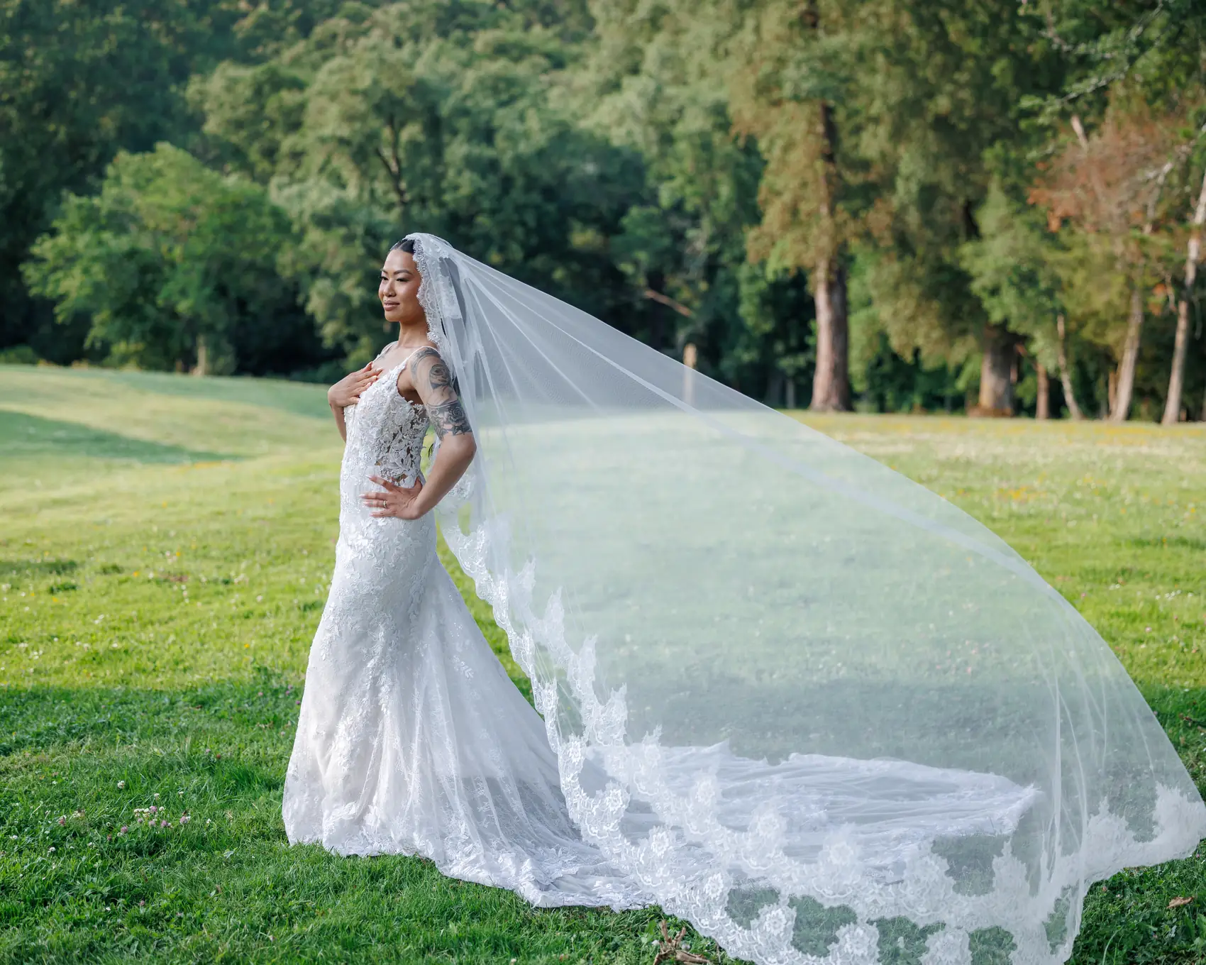 La mariée et son voile déployé dans le parc, en fin de journée